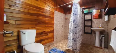 a bathroom with a toilet and a sink at Jardin entre Montañas in Bijagua