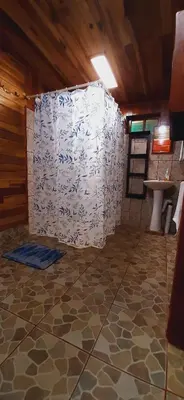 a bathroom with a toilet and a sink in a room at Jardin entre Montañas in Bijagua