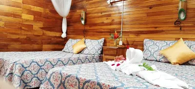 a bedroom with two beds and a stuffed animal on the bed at Jardin entre Montañas in Bijagua