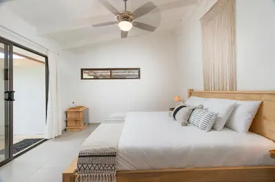 a bedroom with a bed and a ceiling fan at Cafe Playa Negra Hotel in Playa Negra
