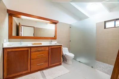 a bathroom with a sink and a toilet and a mirror at Cafe Playa Negra Hotel in Playa Negra