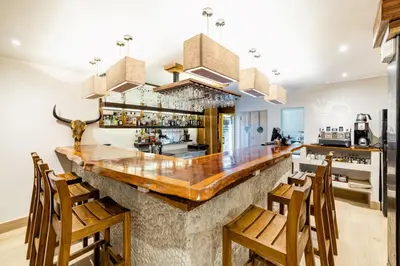 a large kitchen with a bar with wooden chairs at Cafe Playa Negra Hotel in Playa Negra