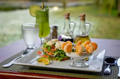 a plate of food with shrimp and salad on a table at Maquenque Lodge in Boca Tapada