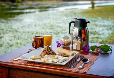 a plate of food on a table with orange juice at Maquenque Lodge in Boca Tapada