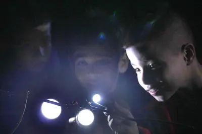 a man holding a light in the dark at FINCA La PAZ - Sarapiqui in Puerto Viejo