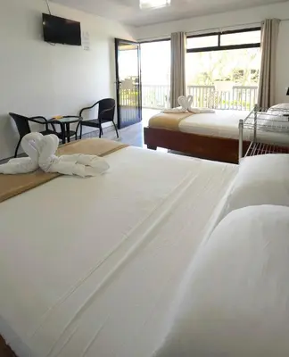 a hotel room with two beds and a balcony at Cattleya Family in Monteverde Costa Rica