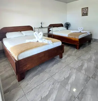 two beds with white bows on them in a room at Cattleya Family in Monteverde Costa Rica