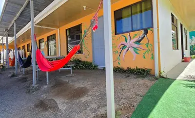 a red hammock in front of a building with a mural at Cattleya Family in Monteverde Costa Rica
