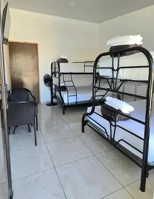 a room with three bunk beds and a mirror at Cattleya Family in Monteverde Costa Rica