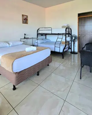 two twin beds in a room with tile floors at Cattleya Family in Monteverde Costa Rica