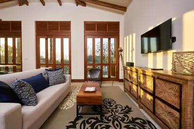a living room with a couch and a tv at Alouatta Guesthouse en Las Catalinas - Beachfront GUESTHOUSE for 6 people in Playa Danta