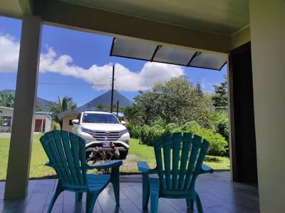 a porch with two chairs and a table and a car at Lisa Loft Boutique Apartment in Fortuna