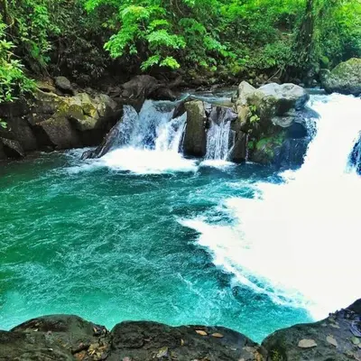 a river with waterfalls and rocks in a forest at Lisa Loft Boutique Apartment in Fortuna