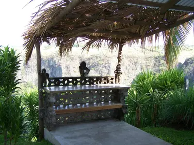 a woman sitting on a bench under a pergola at Vista Canyon Inn in Santa Ana