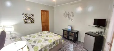 a small bedroom with a bed and a television at Vista Canyon Inn in Santa Ana