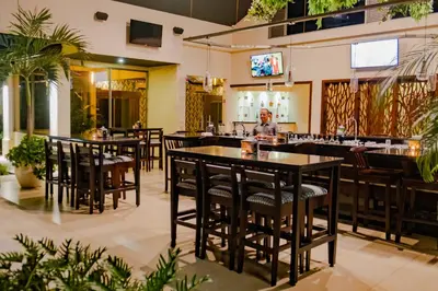 a restaurant with tables and chairs and a person in the background at Hotel Lomas del Volcan in Fortuna