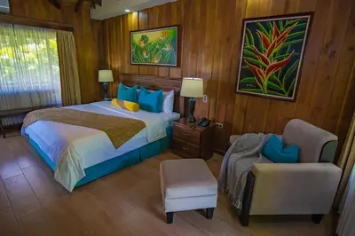 a bedroom with a bed and a chair in it at Hotel Lomas del Volcan in Fortuna