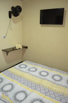 a bedroom with a bed with a television on the wall at #5 Private room close to Airport in Alajuela City