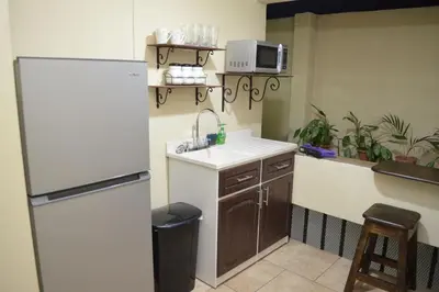 a kitchen with a sink and a refrigerator at #5 Private room close to Airport in Alajuela City