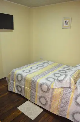 a bedroom with a bed with a blanket on it at #5 Private room close to Airport in Alajuela City