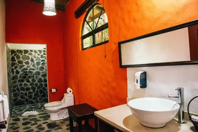 a bathroom with a toilet and a sink and a shower at Hotel Mountain Paradise in Fortuna