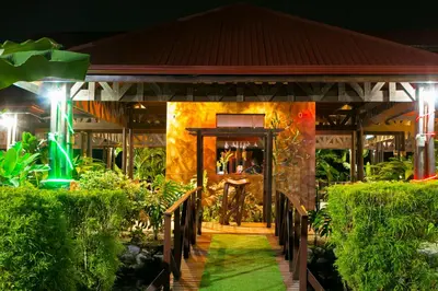 a building with a door in the middle of a garden at Hotel Mountain Paradise in Fortuna