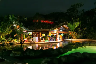 a resort with a swimming pool at night at Hotel Mountain Paradise in Fortuna
