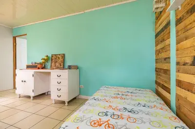 a bedroom with blue walls and a bed and a desk at Casa Mandala by Dreamcatcher in Sarchí
