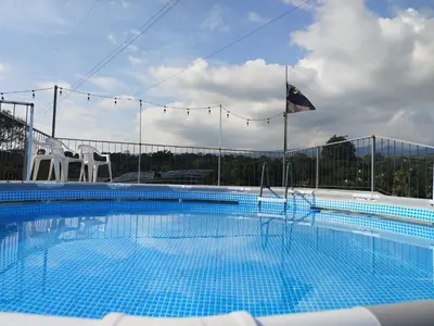 a large swimming pool with two chairs and a flag at Casa Mandala by Dreamcatcher in Sarchí