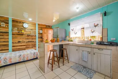 a kitchen with a sink and a counter with stools at Casa Mandala by Dreamcatcher in Sarchí