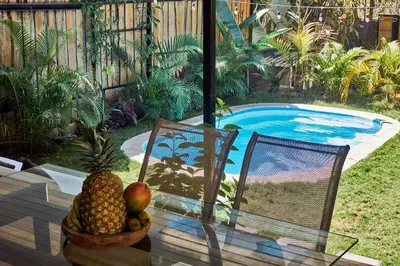a pineapple sitting on a table next to a swimming pool at Villa Flamingo in Santa Teresa Beach