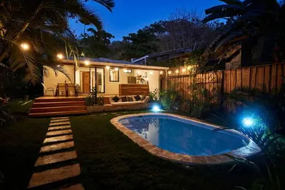a backyard with a swimming pool at night at Villa Flamingo in Santa Teresa Beach