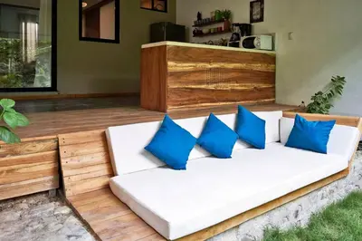 a white couch with blue pillows on a patio at Villa Flamingo in Santa Teresa Beach