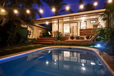 a swimming pool in front of a house at night at Villa Flamingo in Santa Teresa Beach