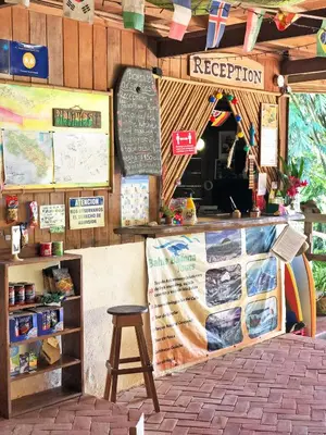 a restaurant with a counter with a sign and a stool at Cascada Verde Eco Lodge & Hostel in Uvita