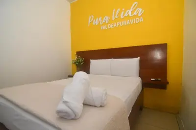 a hotel room with a bed with a white towel on it at Puntarenas Bed & Coffee by Aldea in Puntarenas