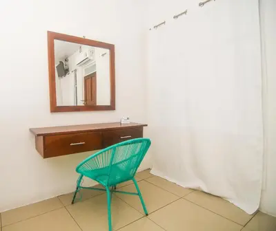 a green chair in a room with a mirror at Puntarenas Bed & Coffee by Aldea in Puntarenas
