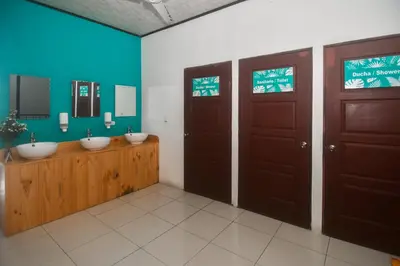 a bathroom with two sinks and two doors at Puntarenas Bed & Coffee by Aldea in Puntarenas