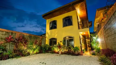 a large yellow house with a building at Sol y Luna Apartments in Fortuna