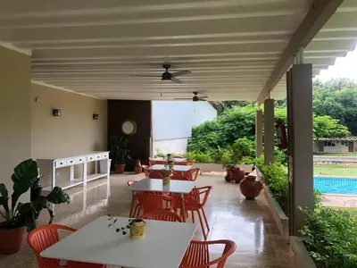a patio with tables and chairs and a pool at Hotel Diriá Santa Cruz in Santa Cruz