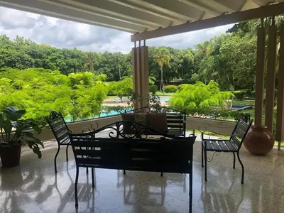 a patio with chairs and a table with a view of a park at Hotel Diriá Santa Cruz in Santa Cruz