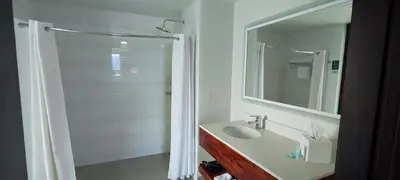 a white bathroom with a shower and a sink at D Sabana Hotel San José in San José