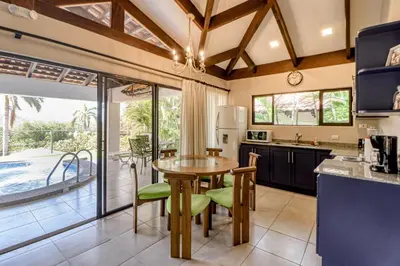 a kitchen with a table and chairs and a patio at Villa Sol 35 in Playa Hermosa
