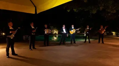 a group of people standing on a stage at night at Capitán Suizo Beachfront Boutique Hotel in Tamarindo
