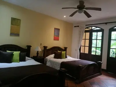a bedroom with two beds and a ceiling fan at Trapp Family Country Inn in San Antonio