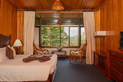 a bedroom with a bed and a large window at Trapp Family Lodge Monteverde in Monteverde Costa Rica