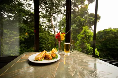 a table with a plate of food and a glass of beer at Trapp Family Lodge Monteverde in Monteverde Costa Rica