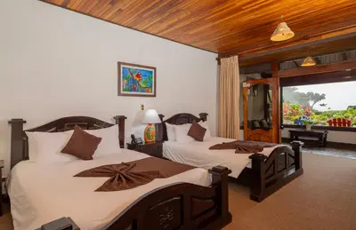 a bedroom with two beds and a window at Trapp Family Lodge Monteverde in Monteverde Costa Rica