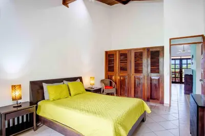a bedroom with a bed with a yellow bedspread at Tropical Condo with Spectacular Ocean Views, Panoramic Dining Terrace & Quick Walk to Beach in Coco