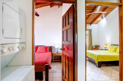 a room with a bedroom with a bed and a door at Tropical Condo with Spectacular Ocean Views, Panoramic Dining Terrace & Quick Walk to Beach in Coco